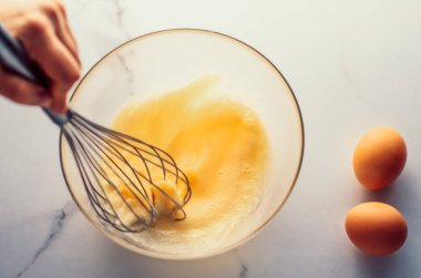 Ev yapımı yemek olarak mermer masada yumurta karıştırmak.