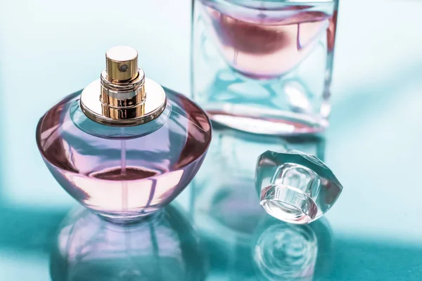 Рожева пляшка парфумів на глянсовому фоні, солодкий квітковий запах, глянцевий — стокове фото