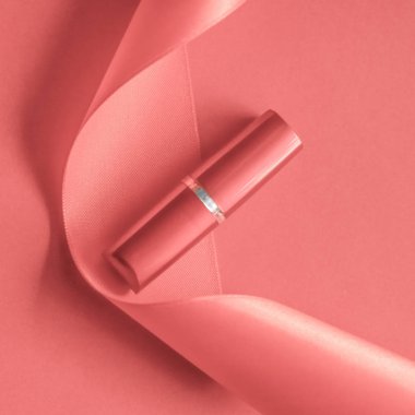 Mercan bayramı arka planında lüks ruj ve ipek kurdele, mak