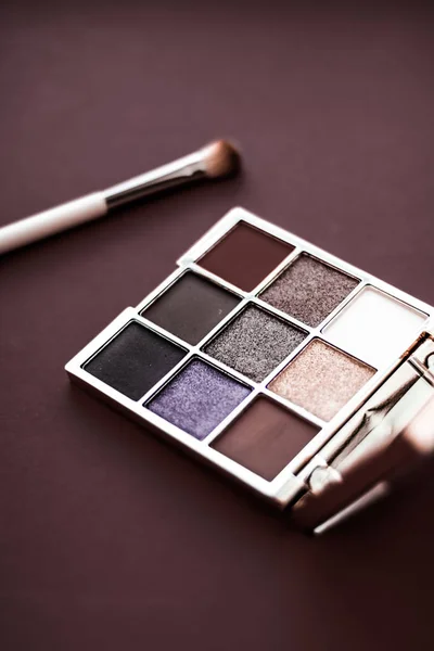 Paleta de sombra de ojos y cepillo de maquillaje sobre fondo de chocolate, ojo — Foto de Stock