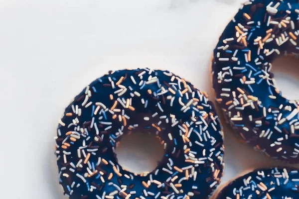 Milchig bestreute Donuts, süßes Gebäck Dessert auf Marmortisch — Stockfoto