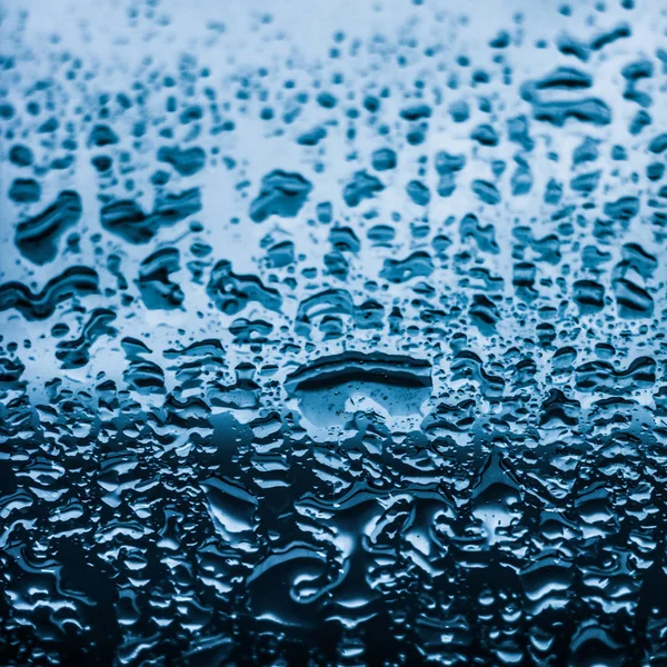 Textura da água fundo abstrato, gotas de água em vidro azul como s — Fotografia de Stock