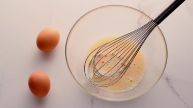 Ev yapımı yiyecek düzlüğü, en iyi görünüm yiyecek markası video grafiği ve yemek pişirme, menü veya diyet planı reklamı olarak mermer masada yumurtaları karıştırmak