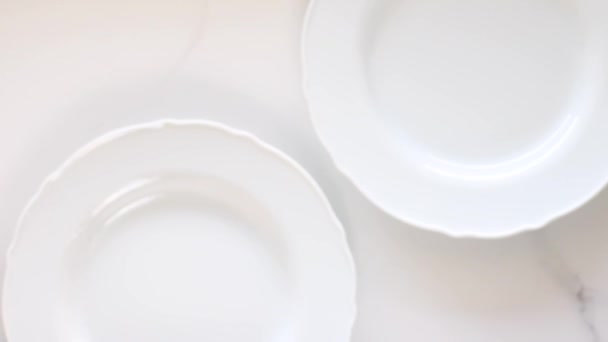 Assiettes vides en porcelaine blanche sur une table en marbre, décor de table plat de dîner, vidéographie des aliments vue du dessus comme source d'inspiration pour la cuisine vlog ou menu flatlay — Video