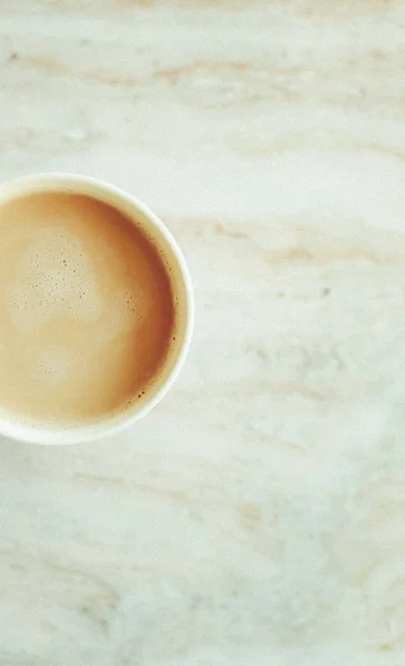 Ranní šálek kávy s mlékem na mramorové kamenné ploše ležel, teplý nápoj — Stock fotografie