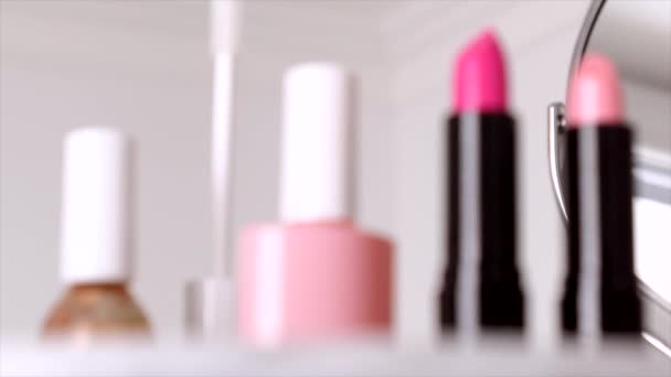Kosmetika, líčidla na toaletním stolku, rtěnka, štětec, řasenka, lak na nehty a pudr pro luxusní design kosmetických a módních reklam — Stock video