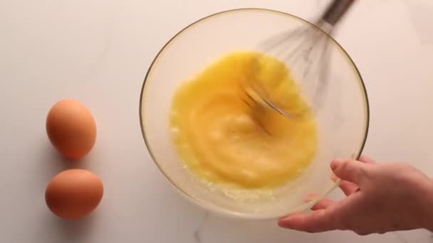 Het maken van het mengen van eieren in kom op marmeren tafel als zelfgemaakt voedsel plat lay, top view food merk videografie flatlay en recept voor koken vlog, menu of dieet plan ad — Stockvideo