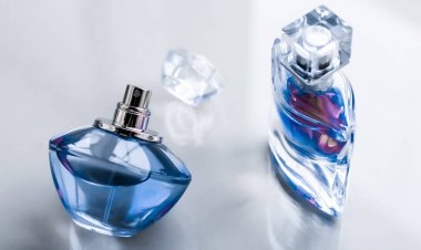 Parlak arka planda mavi parfüm şişesi, tatlı çiçek kokusu, gl
