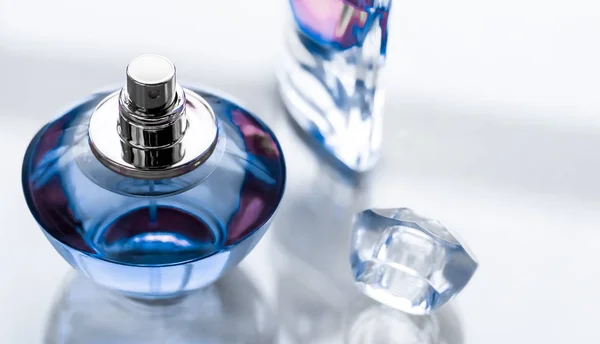 Kék parfümös palack fényes háttérrel, édes virágillat, gl — Stock Fotó