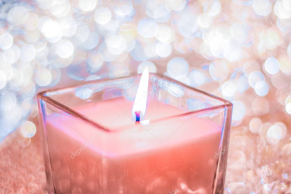 Coral aromatic candle on Christmas and New Years glitter backgro