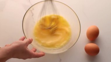 Ev yapımı yiyecek düzlüğü, en iyi görünüm yiyecek markası video grafiği ve yemek pişirme, menü veya diyet planı reklamı olarak mermer masada yumurtaları karıştırmak
