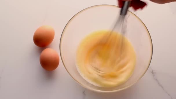 自家製食品フラットレイとして大理石のテーブルの上にボウルに卵を混合すること,トップビュー食品ブランドのビデオ撮影フラットレイと調理用のレシピブログ,メニューや食事計画広告 — ストック動画