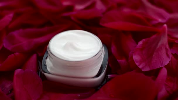 Creme de rosto hidratante de cuidados com a pele sensível em pétalas de flores e fundo de água, ciência natural para a pele — Vídeo de Stock