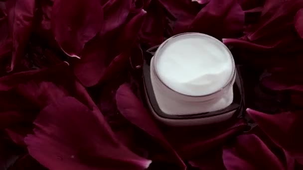 Чувствительный увлажняющий крем для лица от кожи на лепестках цветов и водном фоне, естественные науки для кожи — стоковое видео