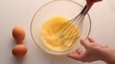 Ev yapımı yiyecek düzlüğü, en iyi görünüm yiyecek markası video grafiği ve yemek pişirme, menü veya diyet planı reklamı olarak mermer masada yumurtaları karıştırmak