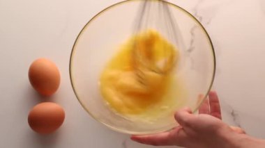 Ev yapımı yiyecek düzlüğü, en iyi görünüm yiyecek markası video grafiği ve yemek pişirme, menü veya diyet planı reklamı olarak mermer masada yumurtaları karıştırmak