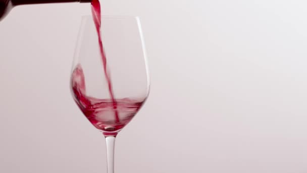 Склянка червоного вина, наливний напій на розкішному святковому дегустаційному заході, контроль якості розбризкування рідкого руху фону для енології або бренду преміум-виноградарства — стокове відео