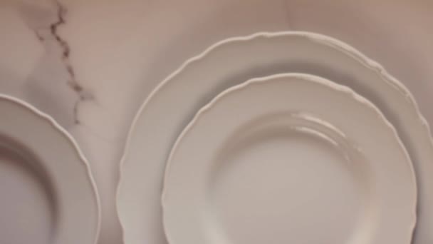 Placas de porcelana branca vazias na mesa de mármore, mesa de jantar decoração flat lay, vista superior videografia de alimentos como inspiração de receita para cozinhar vlog ou menu flatlay — Vídeo de Stock