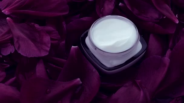 Crema facial hidratante para el cuidado de la piel sensible sobre pétalos de flores y fondo de agua, ciencias naturales para la piel — Vídeos de Stock