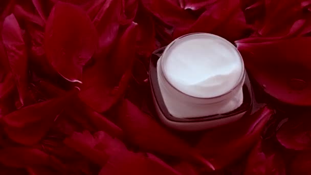 Creme de rosto hidratante de cuidados com a pele sensível em pétalas de flores e fundo de água, ciência natural para a pele — Vídeo de Stock