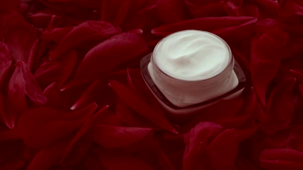 Creme de rosto hidratante de cuidados com a pele sensível em pétalas de flores e fundo de água, ciência natural para a pele — Vídeo de Stock