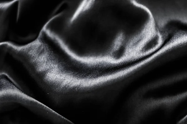 Luxusní černá jemná hedvábná textura plochého pozadí, dovolená — Stock fotografie