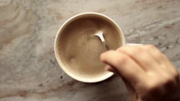 Cangkir kopi pagi dengan susu di atas batu marmer rata, minuman panas di atas flat meja, top melihat videografi makanan dan inspirasi resep untuk memasak vlog — Stok Video