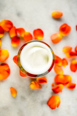 Mermer üzerinde güzellik yüz nemlendirici krem ve çiçek yaprakları, LuXu