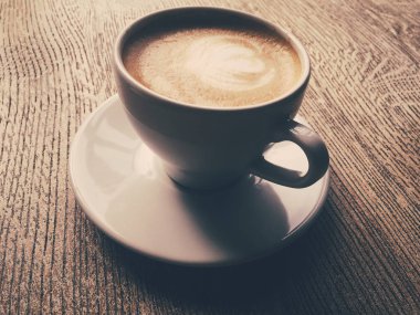 Bir kafeteryasıcak kapuçino Fincan, ahşap bir masada kahve i