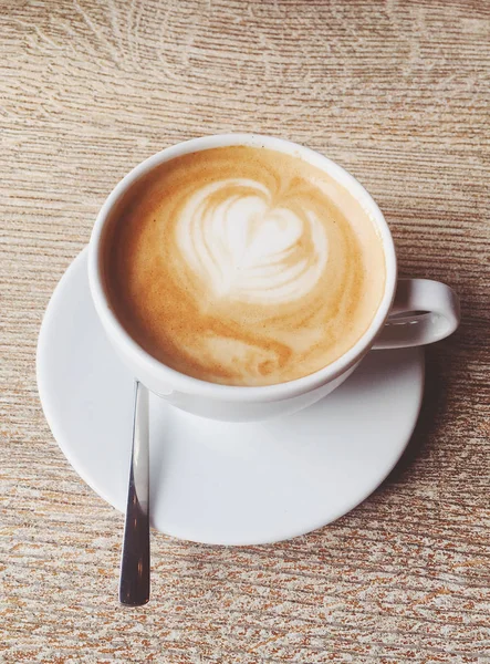 Secangkir cappuccino panas di kantin, kopi di atas meja kayu i — Stok Foto