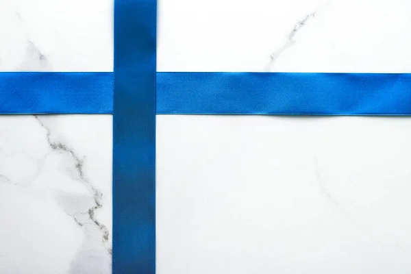 Blue silk ribbon and bow on luxury marble background, holiday fl — Stock Photo, Image