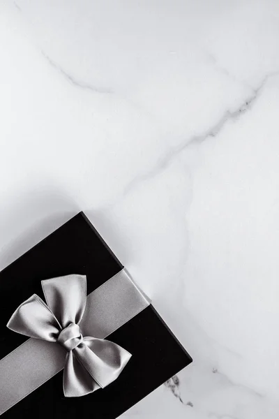 Luxury holiday gifts with silver silk ribbon and bow on marble b — Stock Photo, Image