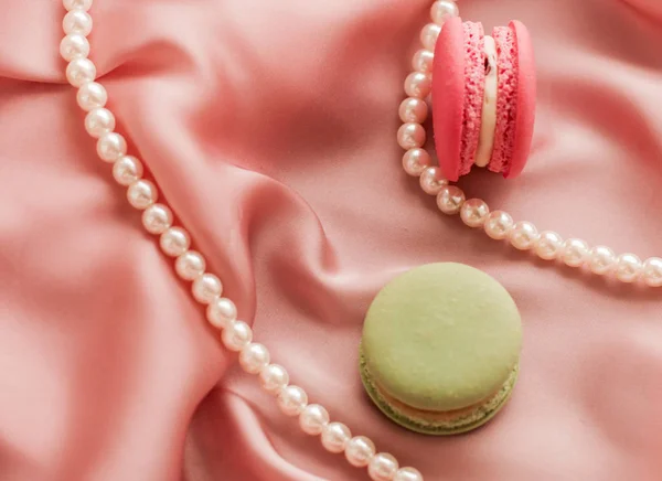 Sweet macaroons and pearls jewellery on silk background, parisia — ストック写真