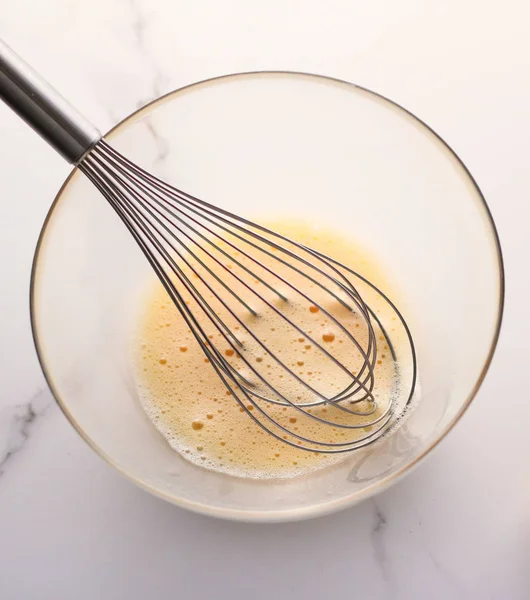 Making of mixing eggs in bowl on marble table as homemade food f — Stock Photo, Image