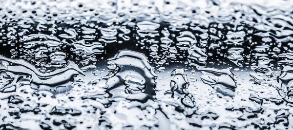 추상적 인 배경의 물 질감, 물은 유리처럼 은 유리 위에 떨어진다 — 스톡 사진