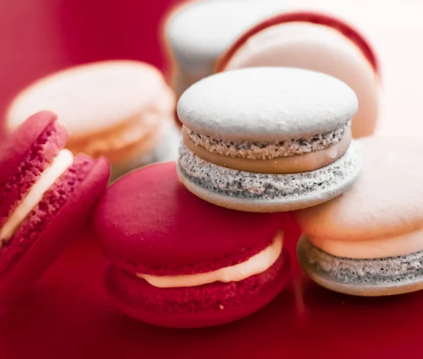 French macaroons on wine red background, parisian chic cafe dess