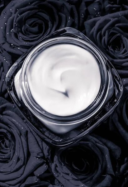 Face cream skin moisturizer and black roses flowers, luxury skin