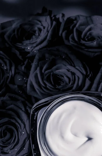 Crema facial hidratante para la piel y rosas negras flores, piel de lujo — Foto de Stock