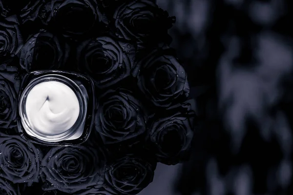 Crema facial hidratante para la piel y rosas negras flores, piel de lujo — Foto de Stock