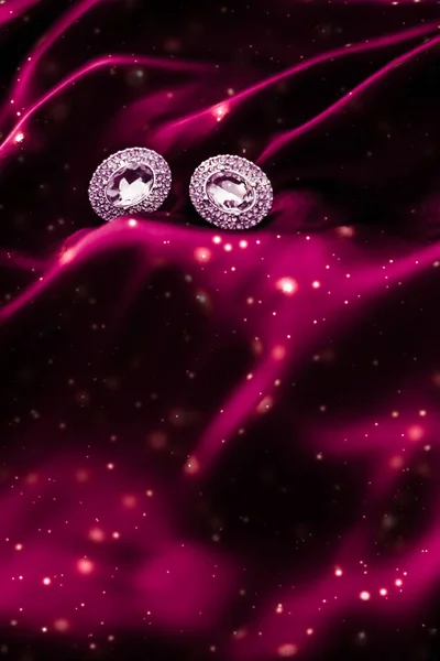 Lyxiga diamantörhängen på mörkt rött siden med snöglitter, Holi — Stockfoto