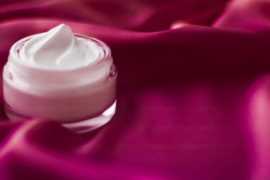 İpek arka planda yüz kremi nemlendirici kavanozu, nemlendirici cilt