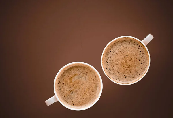 Filiżanka gorącej kawy jako napój śniadaniowy, flatlay kubki na brązowym grzbiecie — Zdjęcie stockowe