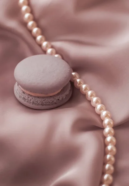 Sweet macaroons and pearls jewellery on silk background, parisia — Stock Photo, Image