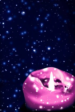 Mavi köpüklü kar arka plan üzerinde pembe tatil mum, lüks