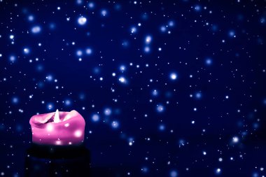 Mavi köpüklü kar arka plan üzerinde pembe tatil mum, lüks