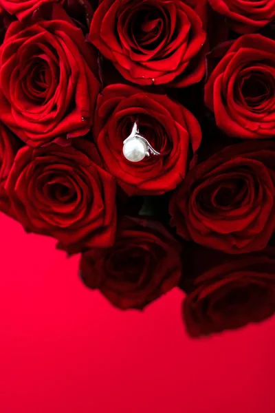 Όμορφο λευκό χρυσό μαργαριτάρι δαχτυλίδι και μπουκέτο από κόκκινα τριαντάφυλλα, πολυτέλεια — Φωτογραφία Αρχείου