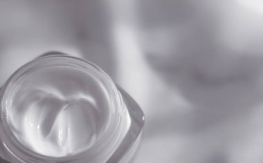 İpek arka planda yüz kremi nemlendirici kavanozu, nemlendirici cilt