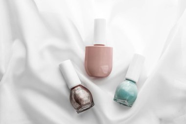 İpek arka planda oje şişeleri, Fransız manikür ürünleri.