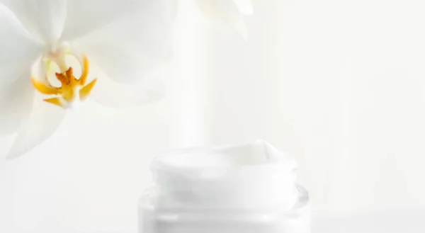 Crema facial hidratante tarro y flor de orquídea, hidratante piel — Foto de Stock