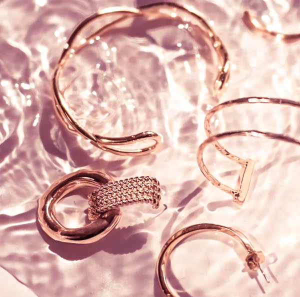 Rózsa arany karkötők, fülbevalók, gyűrűk, ékszerek rózsaszín víz bac — Stock Fotó
